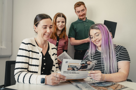 Staff looking at marketing materials in the College